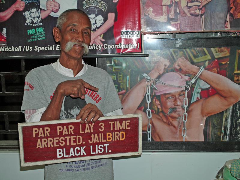 Burma III-061-Seib-2014.jpg - Lu Maw points to a photo of his brother Par Par Lay. He was arrested and imprisoned on three separate occasions by the military government  (Photo by Roland Seib)